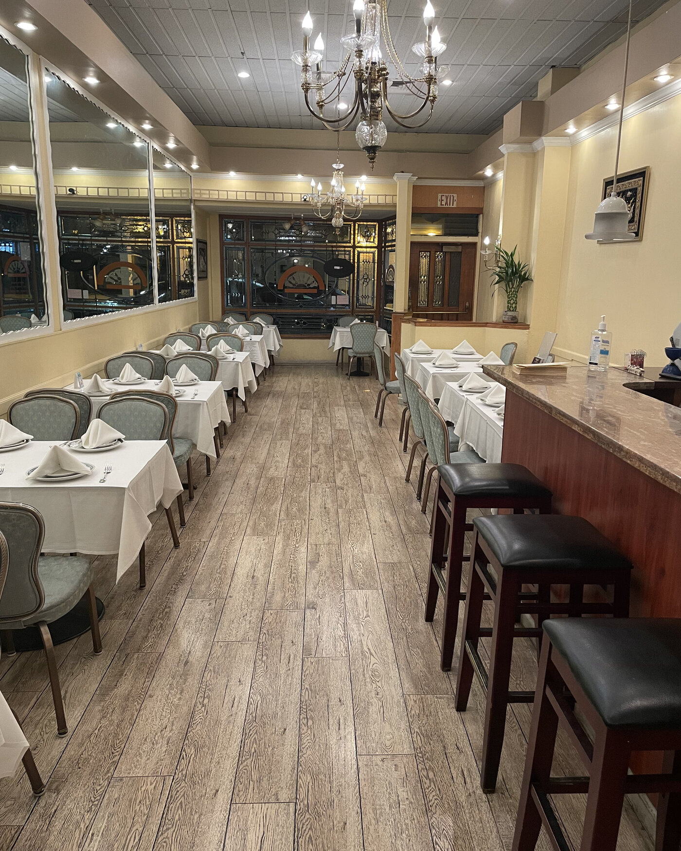 Yangon's dining room, set for service with white linens and warm chandelier light