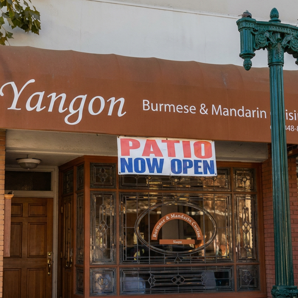 Yangon Burmese and Mandarin cuisine restaurant storefront with a patio now open sign and ornate green streetlamp.